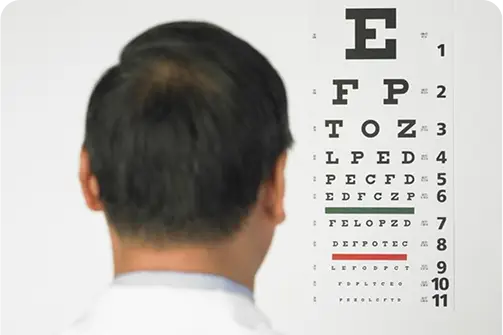 Hindsight eye care specialist conducting a visual acuity test using a Snellen chart to evaluate a patient's eyesight.